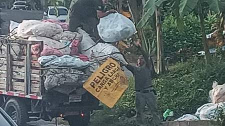 Conductor de un carro tirando escombros en una calle de Bello