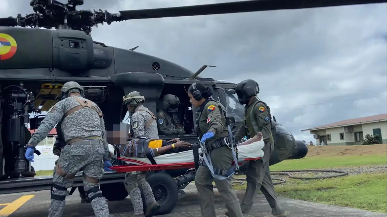 Adulto-mayor-auxiliado-por-hombres-de-la-Fuerza-Aerea-escribe-versiculo-biblico-en-pleno-vuelo
