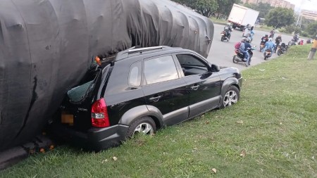 Un vehículo de carga se volcó y cayó encima de un carro particular en la Av. Regional