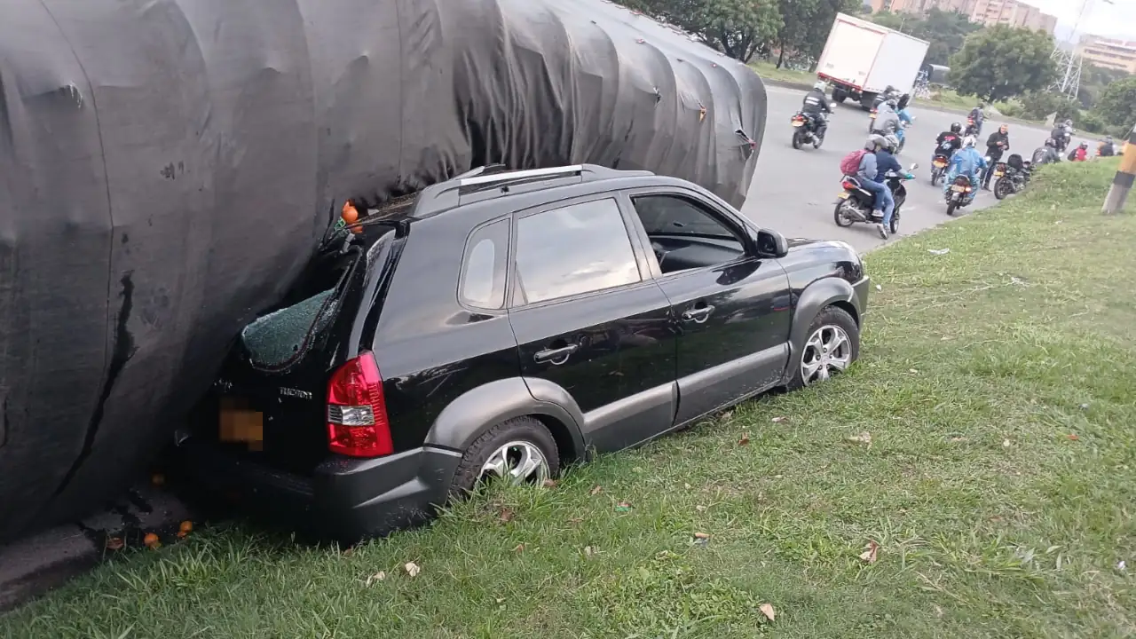 Un vehículo de carga se volcó y cayó encima de un carro particular en la Av. Regional