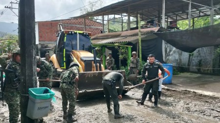 Soldados y policías ayudan a la comunidad limpiando calles después de la inundación en Urabá